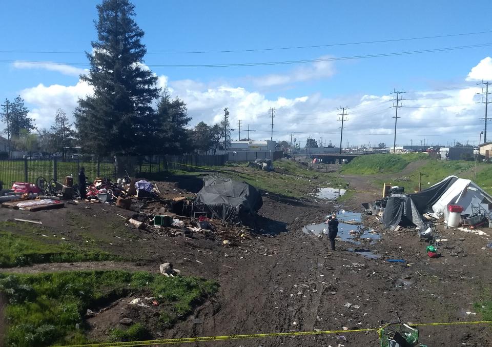 Stockton Police investigators examine a homicide scene in Mormon Slough, near Airport Way on March 5, 2023.