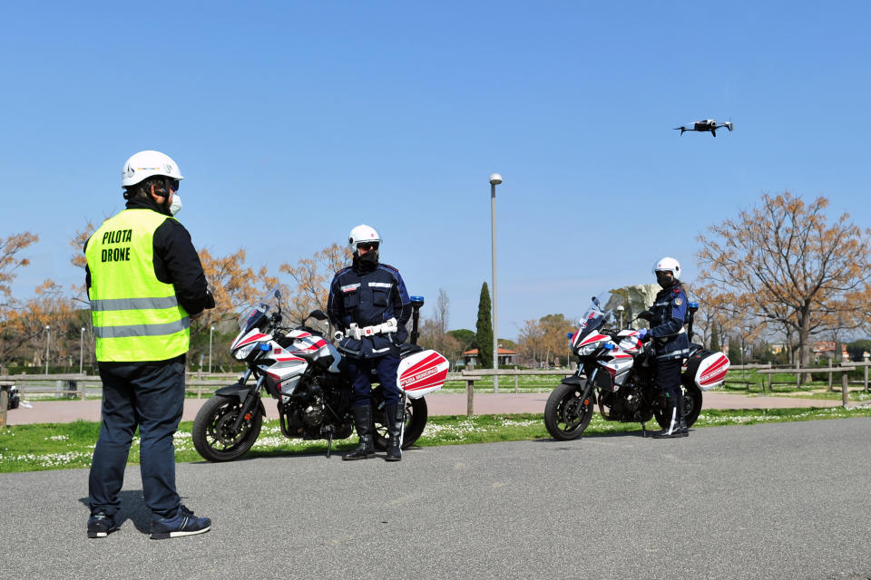 City police officers with the help of a drone monitor citizens' movements in Grosseto, central Italy, Friday, March 20, 2020 as mayors of many towns in Italy are asking for ever more stringent measures on citizens’ movements to help contain the surging infections of the coronavirus. Despite a national lockdown, strictly limiting the justified reasons why they can leave their homes, there have been many violators. For most people, the new coronavirus causes only mild or moderate symptoms. For some it can cause more severe illness.(Jennifer Lorenzini/LaPresse via AP)