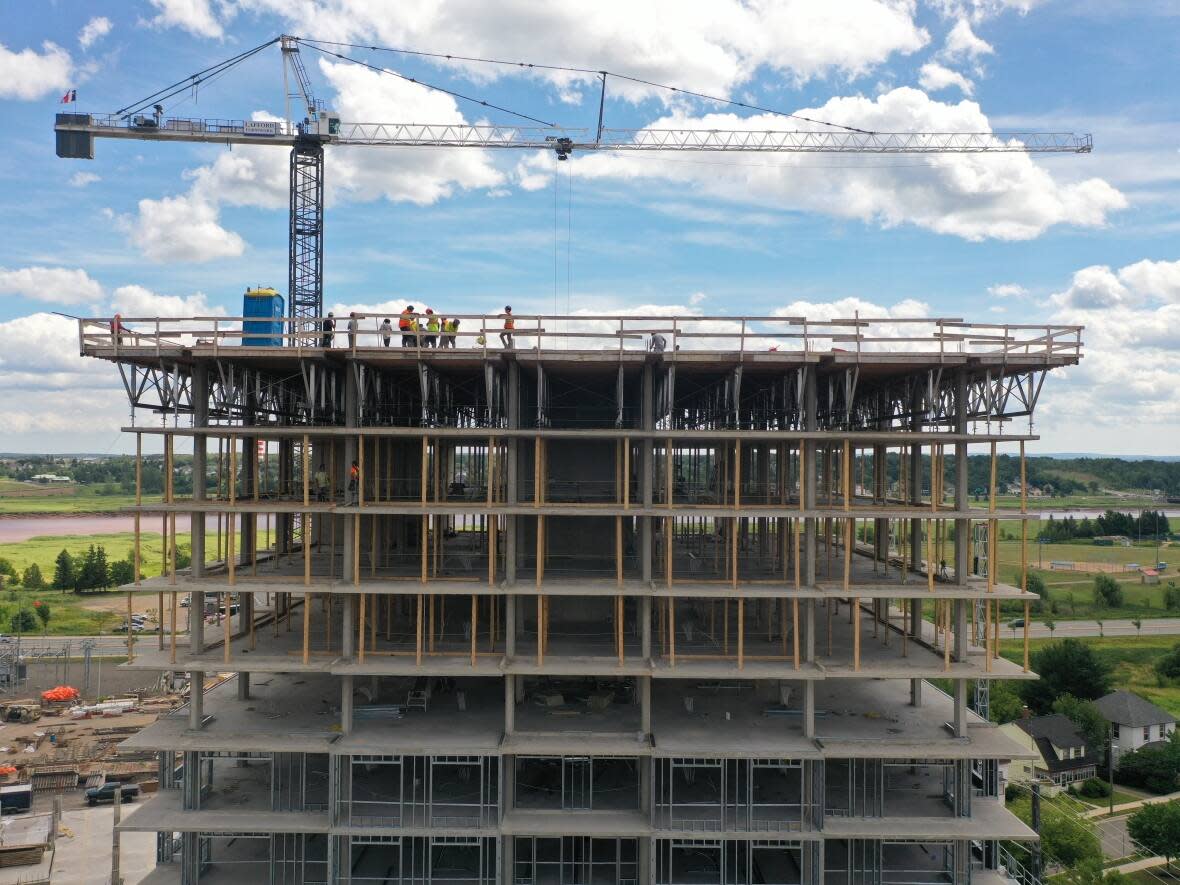 A 15-storey residential tower under construction in downtown Moncton in July, one of several new apartment buildings under construction to accommodate a growing population. (Shane Fowler/CBC - image credit)