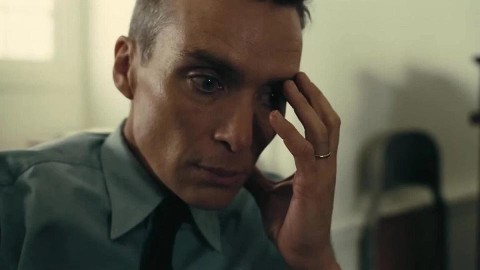 Oppenheimer (Cillian Murphy) touches his head, deep in thought of the horrible thing he'll unleash.