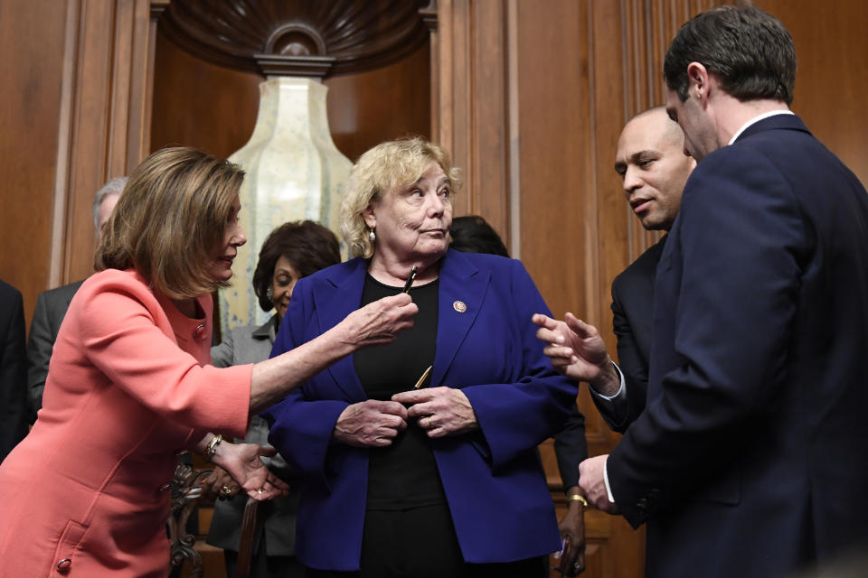 House Speaker Nancy Pelosi of Calif., left, gives a pen to Rep. Hakeem Jeffries, D-N.Y., second from right, after she signed the resolution to transmit the two articles of impeachment against President Donald Trump to the Senate for trial on Capitol Hill in Washington, Wednesday, Jan. 15, 2020. The two articles of impeachment against Trump are for abuse of power and obstruction of Congress. Rep. Zoe Lofgren, D-Calif., center, and Rep. Jason Crow, D-Colo., right, watch. (AP Photo/Susan Walsh)