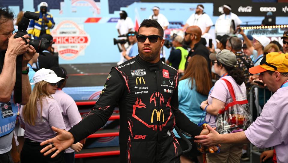 CHICAGO, ILLINOIS - 7 DE JULIO: Bubba Wallace, conductor del Toyota McDonald's n.° 23, saluda a los fanáticos mientras se retira del escenario durante las presentaciones de los pilotos antes de la NASCAR Cup Series Grant Park 165 en Chicago Street Course el 7 de julio de 2024 en Chicago, Illinois. (Foto de Quinn Harris/Getty Images)