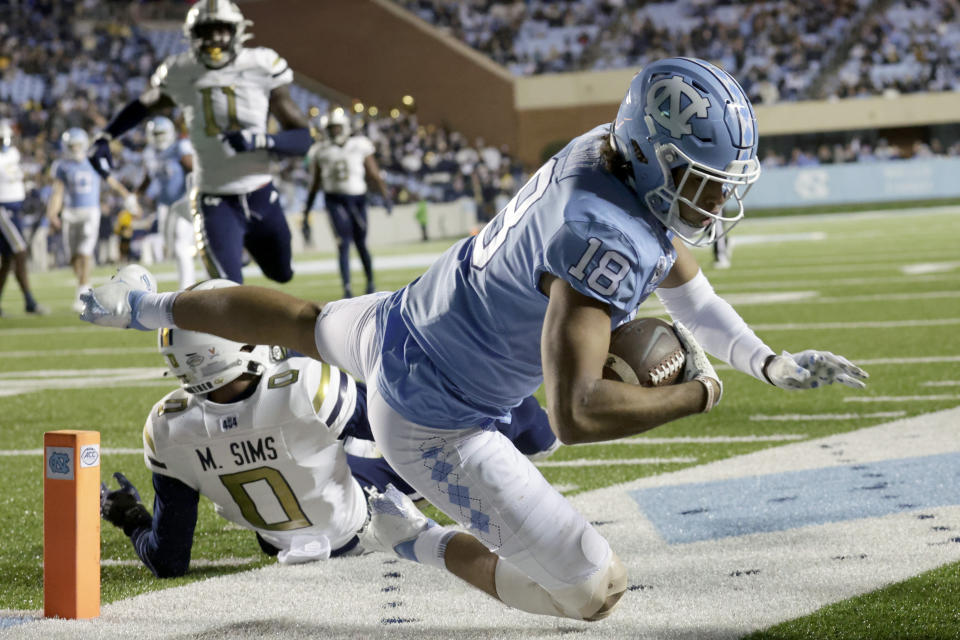 North Carolina tight end Bryson Nesbit (18) is tackled just short of the goal line by Georgia Tech defensive back Myles Sims (0) during the first half of an NCAA college football game, Saturday, Nov. 19, 2022, in Chapel Hill, N.C. North Carolina scored a touchdown on the ensuing drive. (AP Photo/Chris Seward)