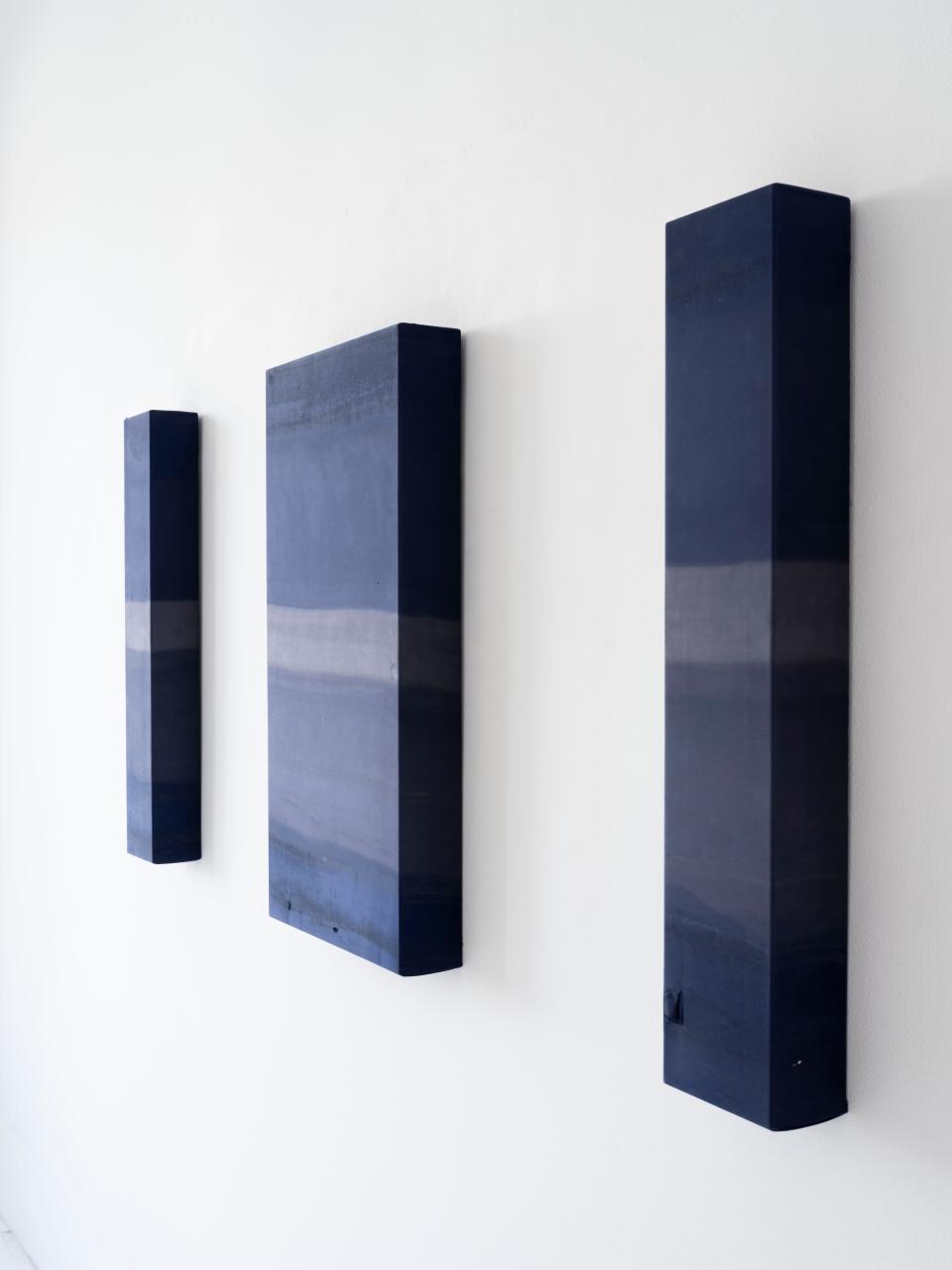 Works by James Perkins on display at COUNTY gallery. The mixed-media wall reliefs are imprinted with the markings of sun, sand, salt, wind, wood and water.