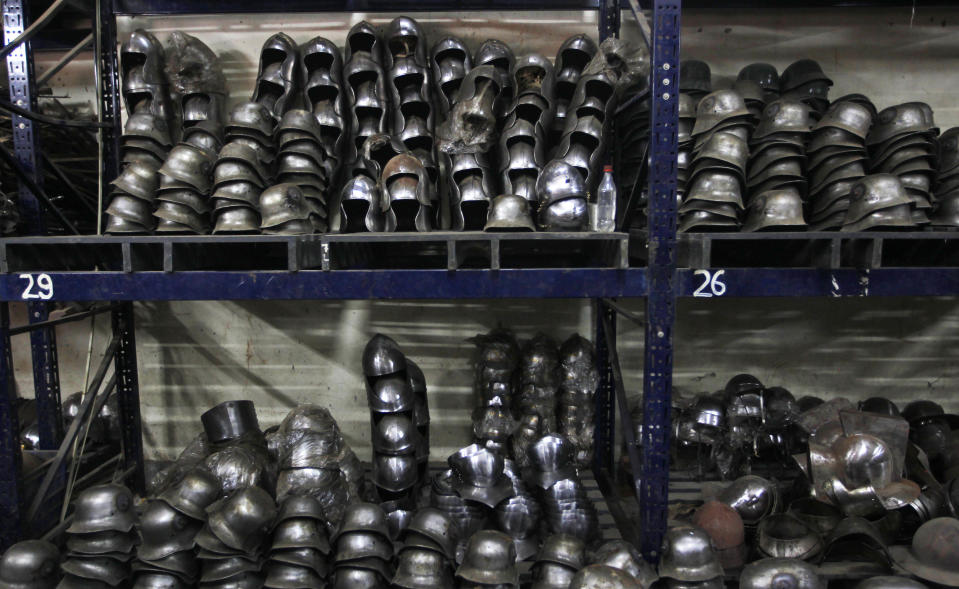 In this, June 2, 2012 photograph, helmets prepared for Hollywood period movies and reenactment events are stacked at a workshop owned by Indian businessman Ashok Rai, unseen, in Sahibabad, India. From Hollywood war movies to Japanese Samurai films to battle re-enactments across Europe, Rai is one of the world's go-to men for historic weapons and battle attire. (AP Photo/Saurabh Das)