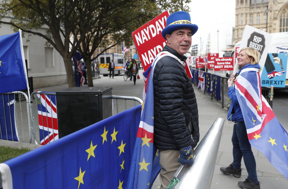 Steve Bray, an anti Brexit protester, holds onto a large megaphone as he demonstrates outside the House of Parliament in London, Tuesday, March 26, 2019. British Prime Minister Theresa May's government says Parliament's decision to take control of the stalled process of leaving the European Union underscores the need for lawmakers to approve her twice-defeated deal. (AP Photo/Alastair Grant)