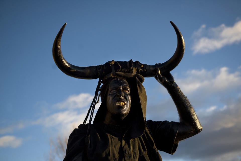 <p>A man covered in oil and soot carrying the horns of a bull on his head and cowbells on a belt (representing the devil) pauses during carnival celebrations in the village of Luzon, Spain, Feb. 9, 2013. (Photo: Daniel Ochoa de Olza/AP) </p>