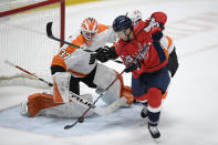 Philadelphia Flyers goaltender Brian Elliott (37) tracks the puck as Washington Capitals right wing Garnet Hathaway (21) tries for a shot during the first period of an NHL hockey game Tuesday, April 13, 2021, in Washington. (AP Photo/Nick Wass)