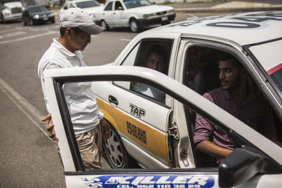 An officer from the National Migration Institute stops a taxi carrying migrants from Bangladesh, at an immigration checkpoint known as Viva Mexico, near Tapachula, Mexico, Friday, June 21, 2019. Mexico's foreign minister says that the country has completed its deployment of some 6,000 National Guard members to help control the flow of Central American migrants headed toward the U.S. (AP Photo/Oliver de Ros)