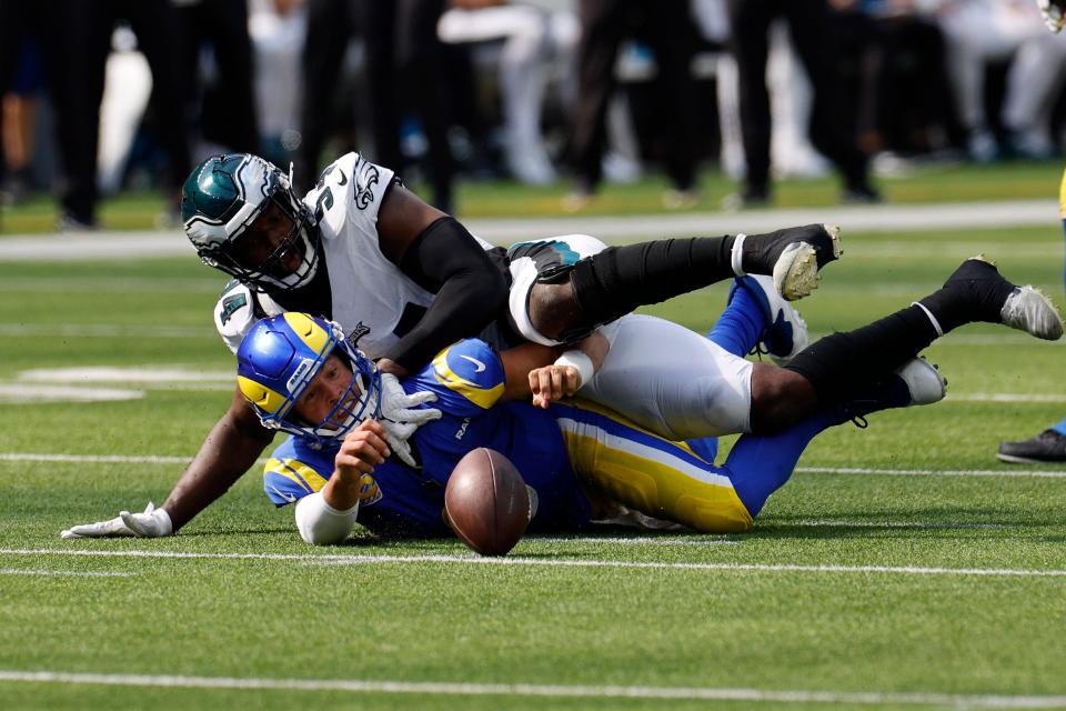 Los Angeles Rams quarterback Matthew Stafford, below, loses the ball after being tackled by Philadelphia Eagles defensive end Josh Sweat during the first half of an NFL football game Sunday, Oct. 8, 2023, in Inglewood, Calif.