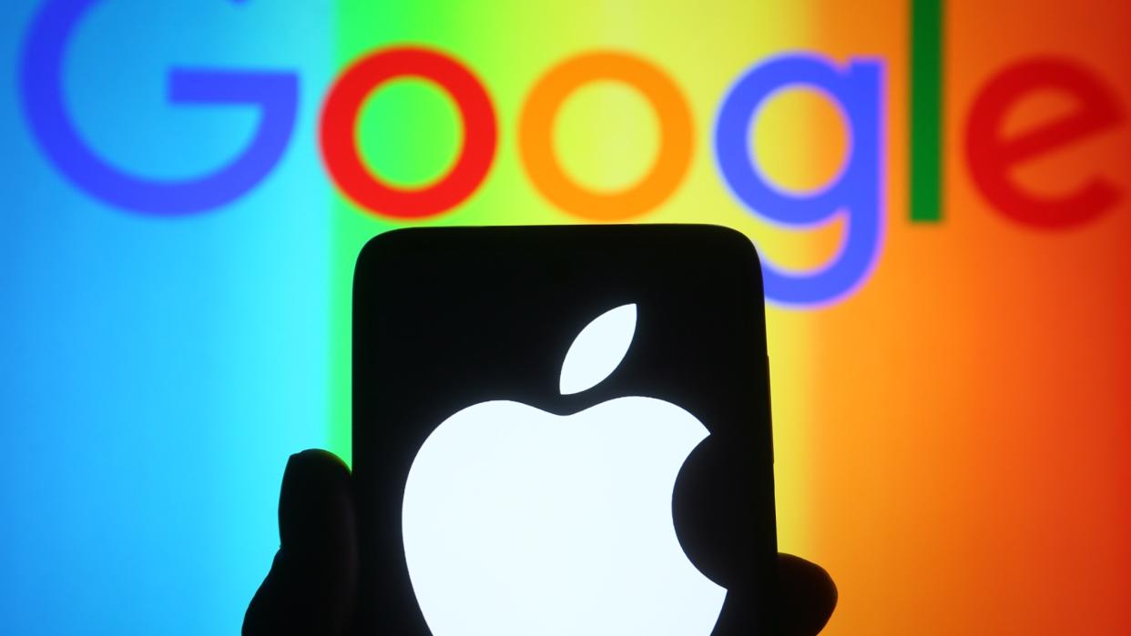  Apple logo on phone with Google logo in the background. 