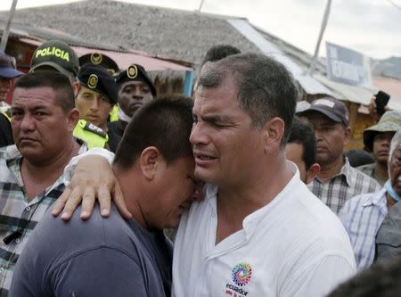Ecuador's President Rafael Correa (R) embraces a resident after the earthquake, which struck off the Pacific coast, in the town of Canoa, Ecuador April 18, 2016. REUTERS/Henry Romero