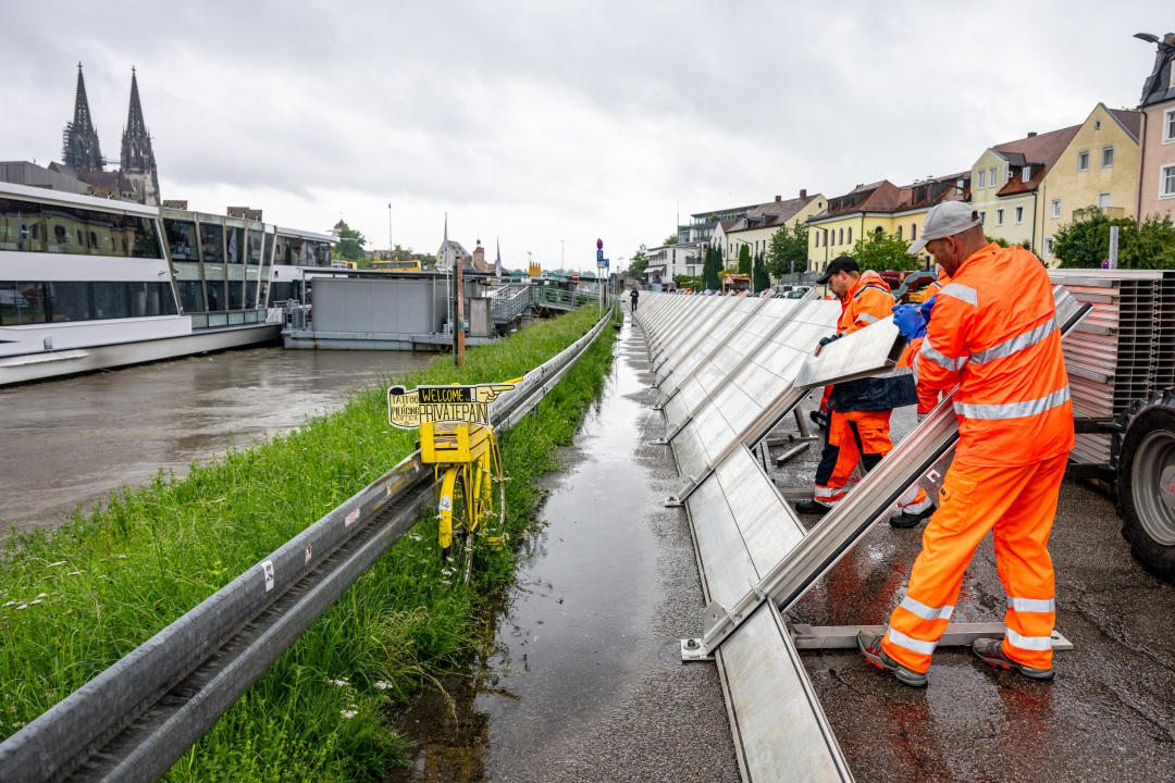 Regensburg: Schutzwände werden in der Altstadt am Donauufer aufgebaut. (Bild: dpa)