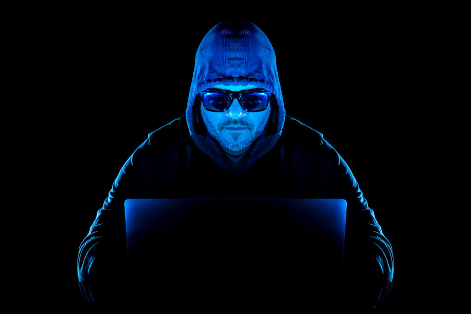 Man behind laptop, man hacker, laptop and personal online security