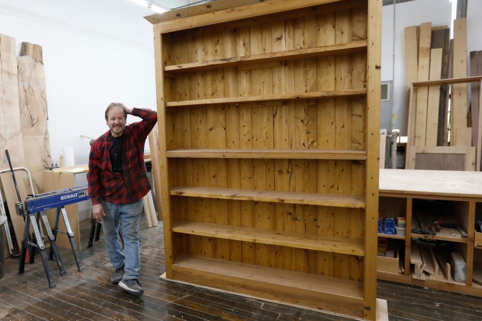 John Giacobbi with a custom built book case he made in his studio at the Hatch Street Studios in New Bedford.