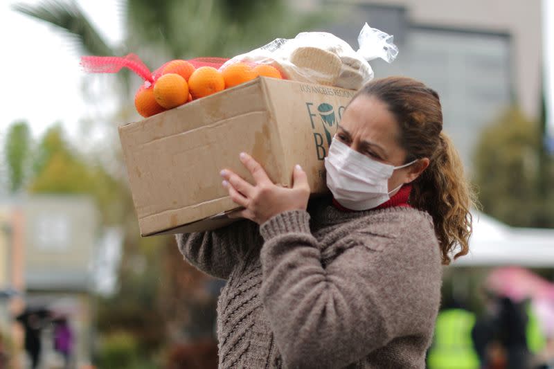 A woman picks up fresh food at a Los Angeles Regional Food Bank giveaway of 2,000 boxes of groceries, as the spread of the coronavirus disease (COVID-19) continues, in Los Angeles