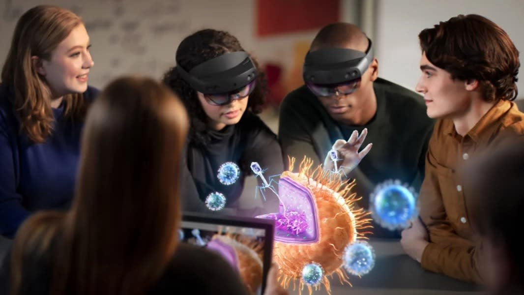  A group of standing around a holographic image in a classroom setting to depict what is seen in Microsoft HoloLens which is worn by two of the students. 