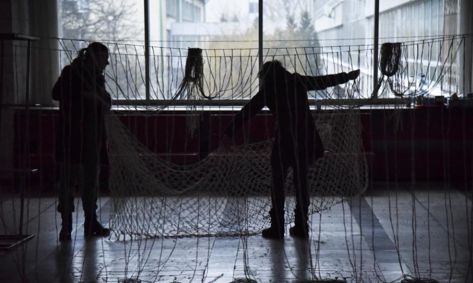 People weave camouflage nets for the Ukrainian military in the dark, Lviv, 10 January, 2023.