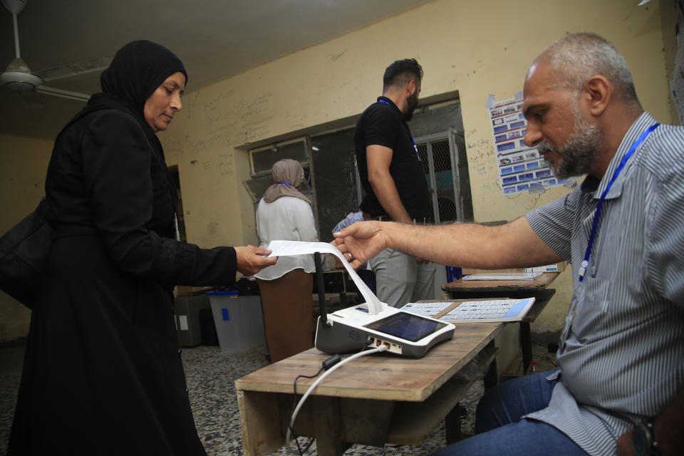 Employees of the Independent High Electoral Commission close a polling station at the end of parliamentary elections, in Baghdad, Iraq, Sunday, Oct. 10, 2021. Iraq closed its airspace and land border crossings on Sunday as voters headed to the polls to elect a parliament that many hope will deliver much needed reforms after decades of conflict and mismanagement. (AP Photo/Hadi Mizban)