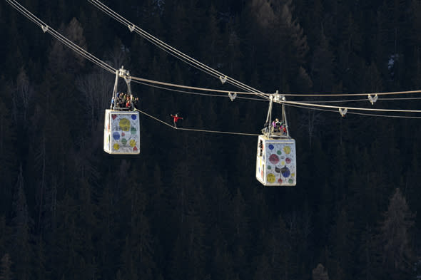 French highliner Julien Millot performs on the Paradiski cable way, 380m high, designed by French creator Jean-Charles de Castelbajac, on December 16, 2013 in front of the Mont Blanc mountain in La Plagne.      AFP PHOTO / JEAN-PIERRE CLATOT        (Photo credit should read JEAN-PIERRE CLATOT/AFP/Getty Images)