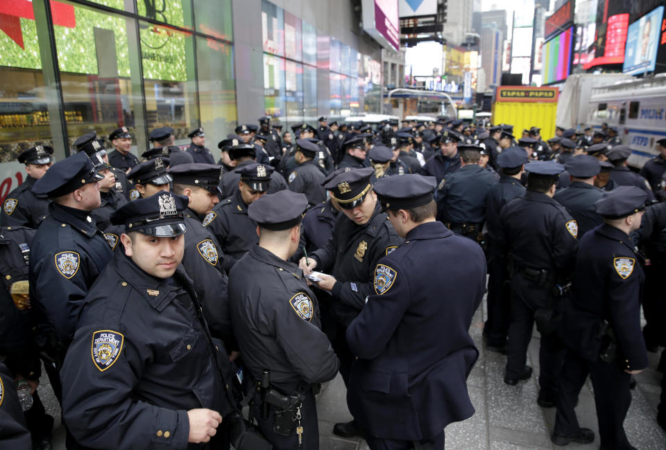 FILE - In this Dec. 31, 2015, file photo, police officers gather at the southern end of Times Square to receive their assignments for New Year's Eve in New York. Although New York City police have turned to familiar tactics ahead of the iconic Thursday, Dec. 31, 2020, ball drop, the department's playbook this year includes an unusual mandate: preventing crowds from gathering in Times Square. (AP Photo/Seth Wenig, File)