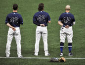 From left to right, Tampa Bay Rays' Joey Wendle, Brett Phillips and Mike Brosseau wear No. 42 on their jerseys in honor of Jackie Robinson Day before a baseball game against the Texas Rangers, Thursday, April 15, 2021, in St. Petersburg, Fla. (AP Photo/Steve Nesius)
