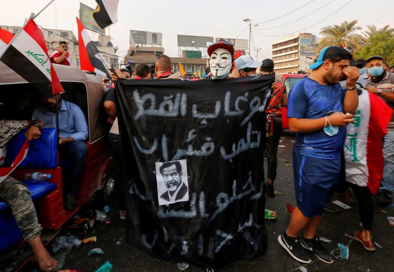 A demonstrator wears a mask during a protest over corruption, lack of jobs, and poor services, in Baghdad