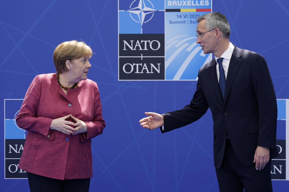 German Chancellor Angela Merkel speaks with NATO Secretary General Jens Stoltenberg as they pose for photos at the NATO summit at NATO headquarters in Brussels, Monday, June 14, 2021. (AP Photo/Patrick Semansky, Pool)
