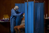 A Spanish NGO Open Arms volunteer takes a swab to test a woman for COVID-19, at Vilafranca del Penedes in the Barcelona province, Spain, Tuesday, Aug. 11, 2020. Spain is facing another surge in coronavirus infections not even two months after beating back the first wave. (AP Photo/Emilio Morenatti)