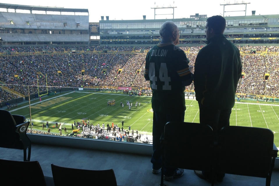 In this October 2012 photo provided by Karen Gooch, former Green Bay Packers football player Bobby Dillon and his grandson, Weston Gooch are shown in a suite at Lambeau Field in Green Bay, Wisc. He left with an outstanding resume, but also with the ugly remnants of a series of concussions from playing football. Of the 26 men who entered the Pro Football Hall of Fame as Packers and preceded Bobby Dillon into the shrine, nearly all won an NFL championship in Green Bay. Dillon never got the chance. (Karen Gooch via AP)