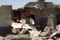A Yemeni man looks at the ruins of his house in Sanaa after it was destroyed in an air strike by Saudi-led coalition warplanes, on March 31, 2015