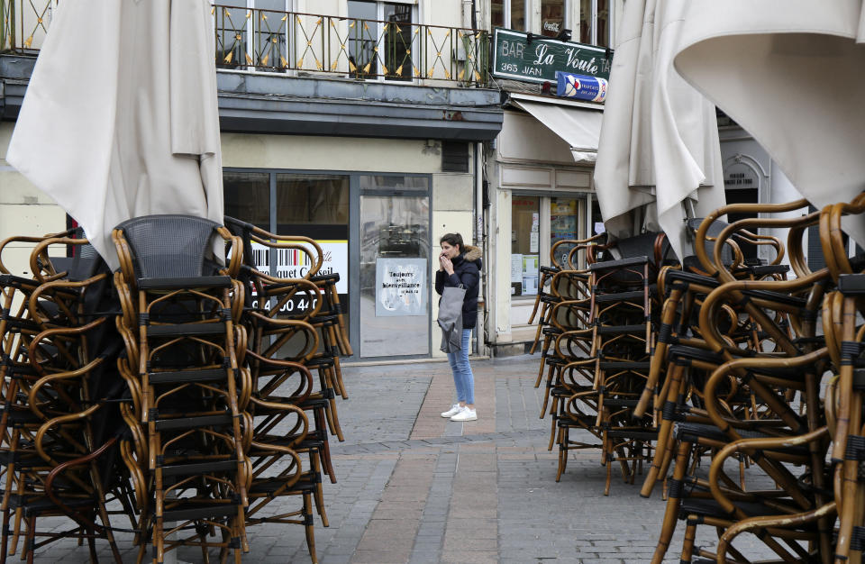 A woman stands in the main square in Lille, northern France, Sunday March 15, 2020. French Prime Minister Edouard Philippe announced that France is shutting down all restaurants, cafes, cinemas and non-essential retail shops, starting Sunday, to combat the accelerated spread of the virus in the country. For most people, the new coronavirus causes only mild or moderate symptoms. For some it can cause more severe illness. (AP Photo/Michel Spingler)