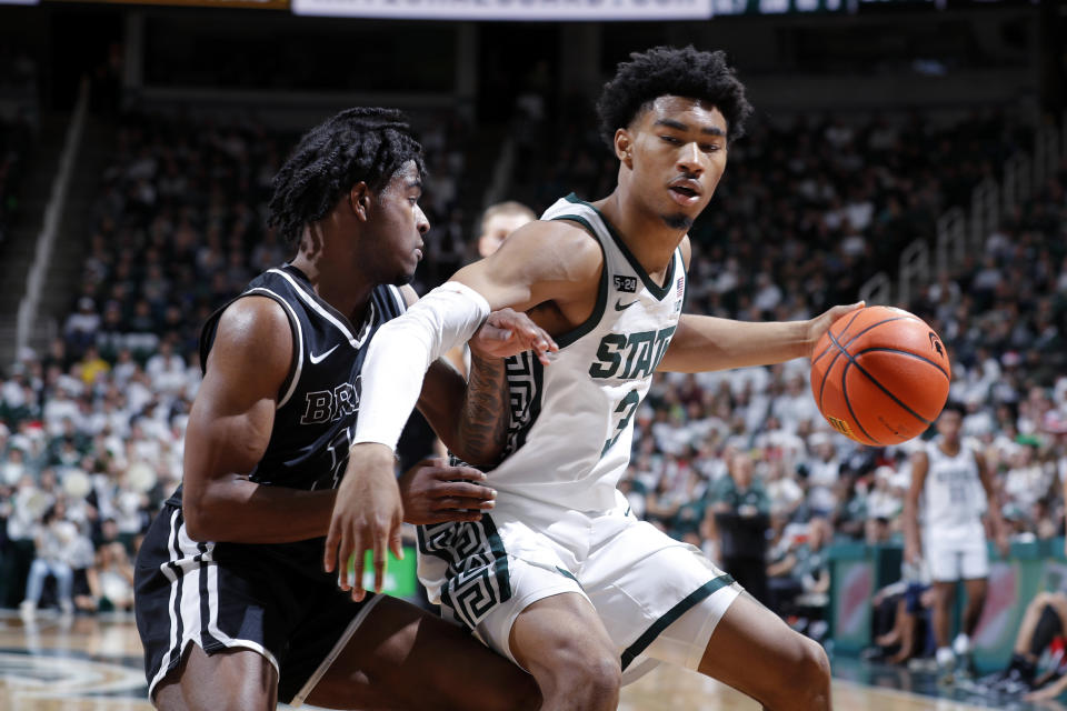 Michigan State's Jaden Akins, right, drives against Brown's Kino Lilly Jr. during the first half of an NCAA college basketball game, Saturday, Dec. 10, 2022, in East Lansing, Mich. (AP Photo/Al Goldis)