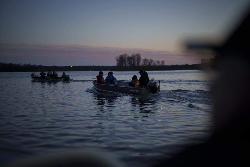 Tribal members ferry kids on boats during a youth spearfishing event on the Lac du Flambeau Reservation, Saturday, April 20, 2024, in Lac Du Flambeau, Wis. (AP Photo/John Locher)