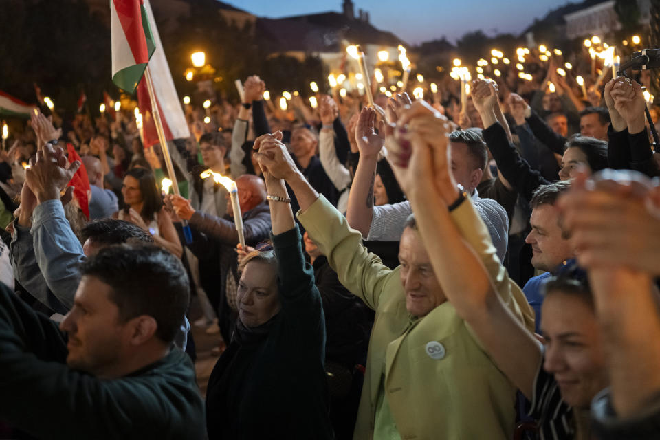 People hold each others hands during a campaign rally of Péter Magyar, a former Fidesz insider that broke ranks with the party in February in Vac, Hungary, on May 18, 2024. Magyar, 43, seized on growing disenchantment with the populist Prime Minister Viktor Orbán, building a political movement that in only a matter of weeks looks poised to become Hungary's largest opposition force. (AP Photo/Denes Erdos)