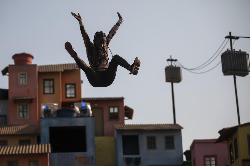 A Brazilian artist from the Nossa Pele group performs on a stage with scenery that looks like a favela at the Rock in Rio music festival in Rio de Janeiro, Brazil, Friday, Sept. 9, 2022. (AP Photo/Bruna Prado)