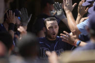 Tampa Bay Rays' Brandon Lowe, right, high-fives teammates as he reaches the dugout after hitting a two-run home run against the Oakland Athletics during the sixth inning of a baseball game Saturday, May 8, 2021, in Oakland, Calif. (AP Photo/Tony Avelar)