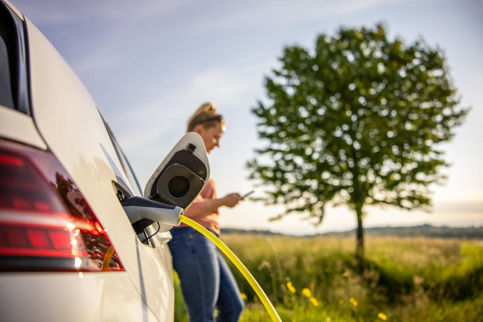 Woman on her phone while her car charges