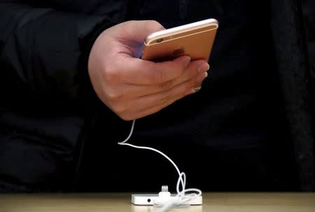 A customer holds an iPhone 6s during the official launch at the Apple store in central Sydney, Australia, September 25, 2015. REUTERS/David Gray