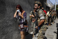 Lebanese army special forces soldiers protect teachers as they flee their school after deadly clashes erupted along a former 1975-90 civil war front-line between Muslim Shiite and Christian areas, at Ain el-Remaneh neighborhood, in Beirut, Lebanon, Thursday, Oct. 14, 2021. Armed clashes broke out in Beirut Thursday during the protest against the lead judge investigating last year's massive blast in the city's port, as tensions over the domestic probe boiled over. (AP Photo/Hussein Malla)