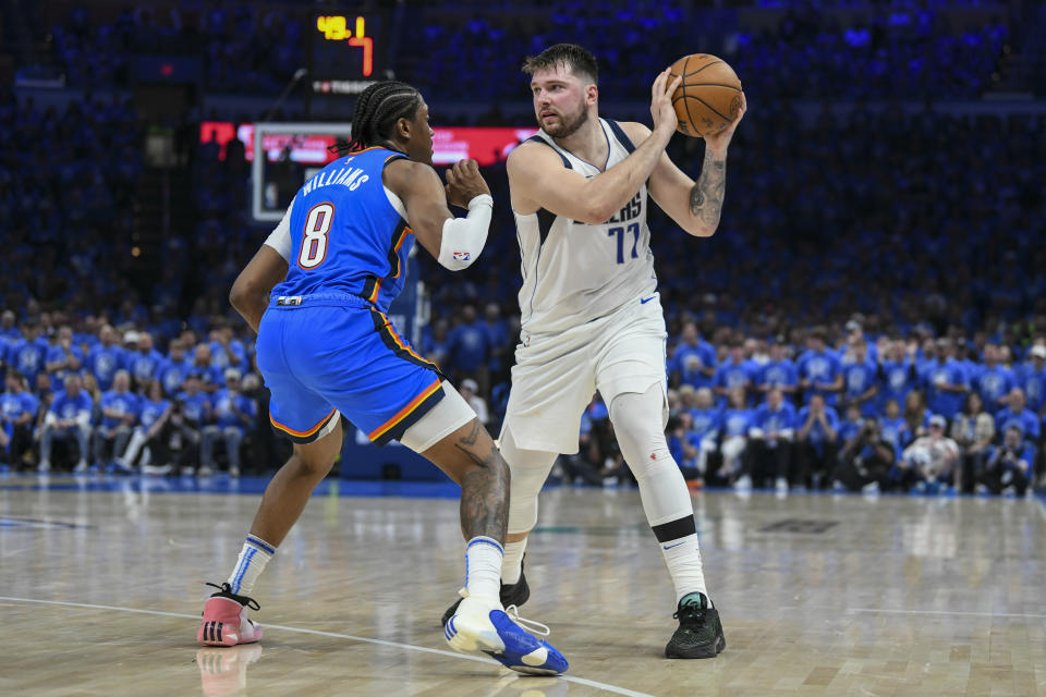 Dallas Mavericks guard Luka Doncic (77) works the floor against Oklahoma City Thunder forward Jalen Williams (8) during the first half in Game 2 of an NBA basketball second-round playoff series, Thursday, May 9, 2024, in Oklahoma City. (AP Photo/Kyle Phillips)