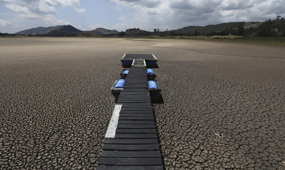 FILE - In this Wednesday, Feb. 17, 2021 file photo, a floating dock sits on the lakebed of the Suesca lagoon, in Suesca, Colombia. The lagoon, a popular tourist destination near Bogota that has no tributaries and depends on rain runoff, has radically decreased its water surface due to years of severe droughts in the area and the deforestation and erosion of its surroundings. (AP Photo/Fernando Vergara, File)