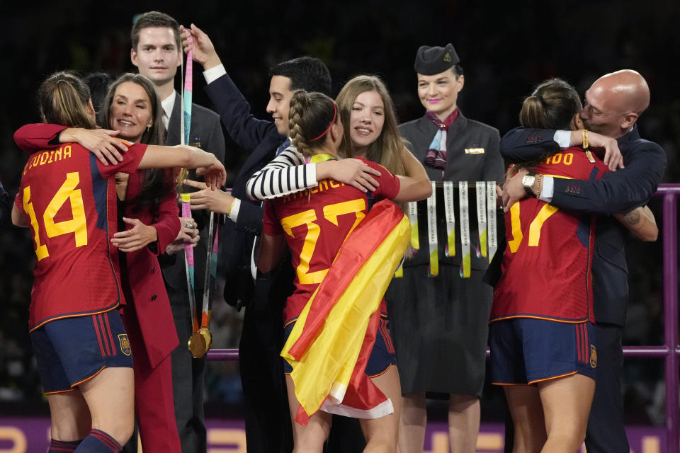 President of Spain's soccer federation, Luis Rubiales, right, embraces Alba Redondo as Queen Letizia of Spain, second left, congratulates Laia Codina, and Princess Infanta Sofia embraces Athenea Del Castillo during the awards ceremony for the Women's World Cup soccer final at Stadium Australia in Sydney, Australia, Sunday, Aug. 20, 2023. Spain defeated England in the final. (AP Photo/Rick Rycroft)