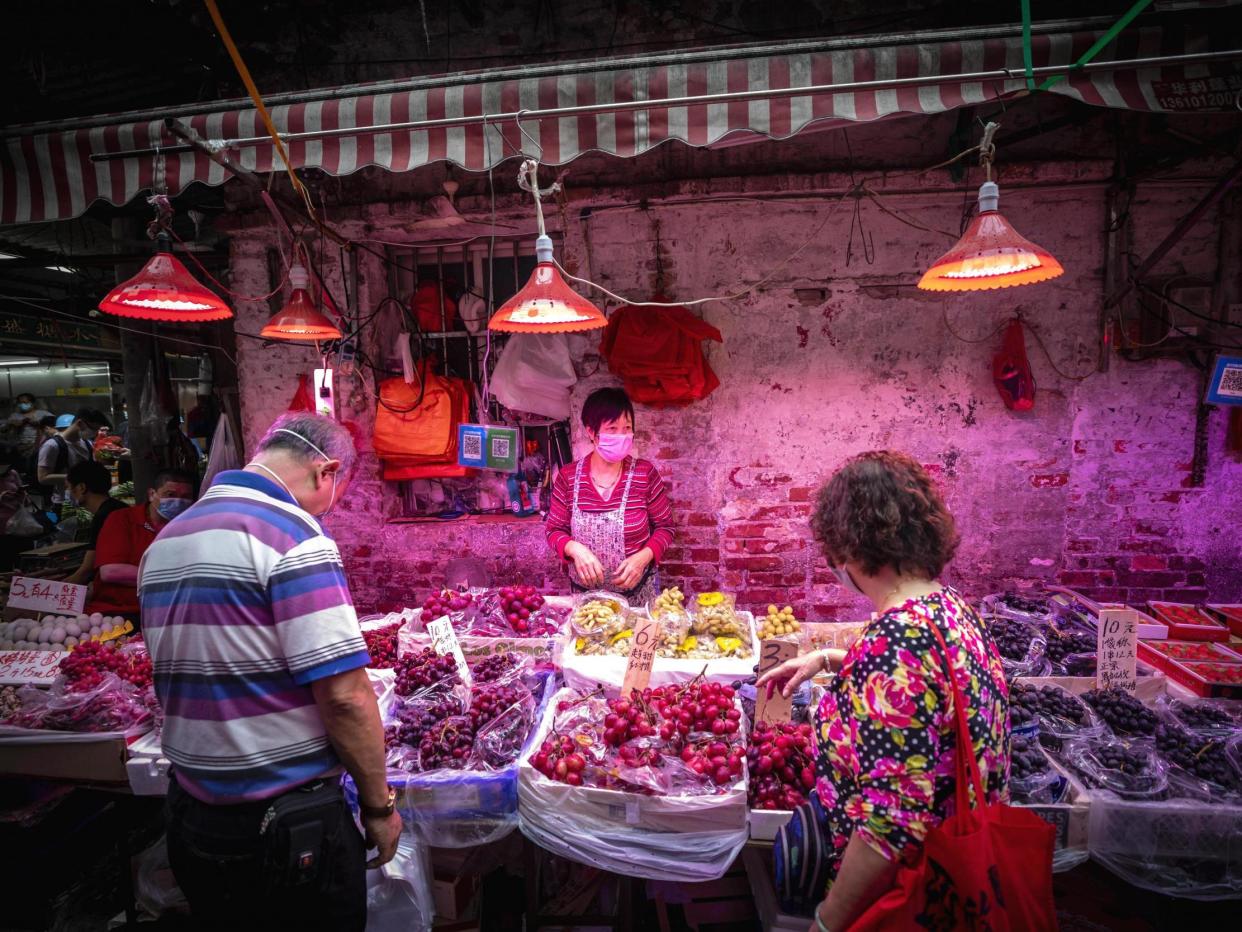 People buy food at a wet market in Guangzhou, China: EPA/ALEX PLAVEVSKI