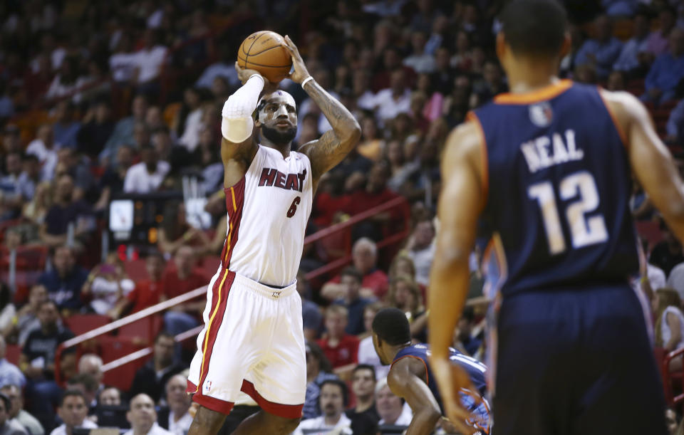 MIami Heat's LeBron James (6) shoots a three point shot as Charlotte Bobcats' Gary Neal (14) watches during the first half of an NBA basketball game in Miami, Monday, March 3, 2014. (AP Photo/J Pat Carter)