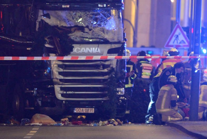 Rescue workers inspect the truck that crashed into a Christmas market close to the Kaiser Wilhelm memorial church in Berlin, Germany, on December 19, 2016. File Photo by Paul Zinken/EPA