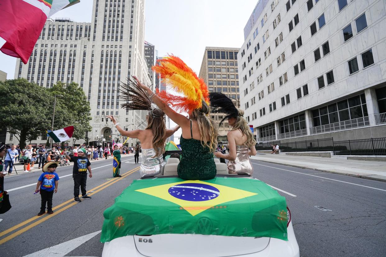 Aliandra Robertson, center, waves to people on the sidewalk Sept. 17, during the first Columbus Latine/Hispanic Heritage Month parade.