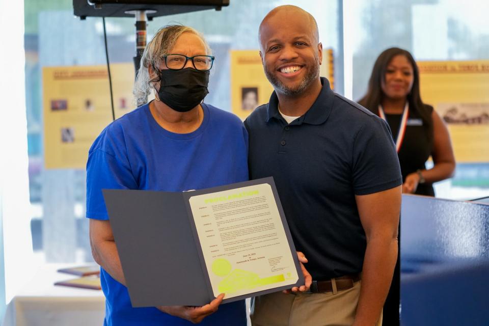 Jun 18, 2022; Tempe, Ariz., U.S.;  Tempe Mayor Corey Woods (right) presents African American Advisory Committee Treasurer Willie Mae Crosby with a Juneteenth Proclamation.