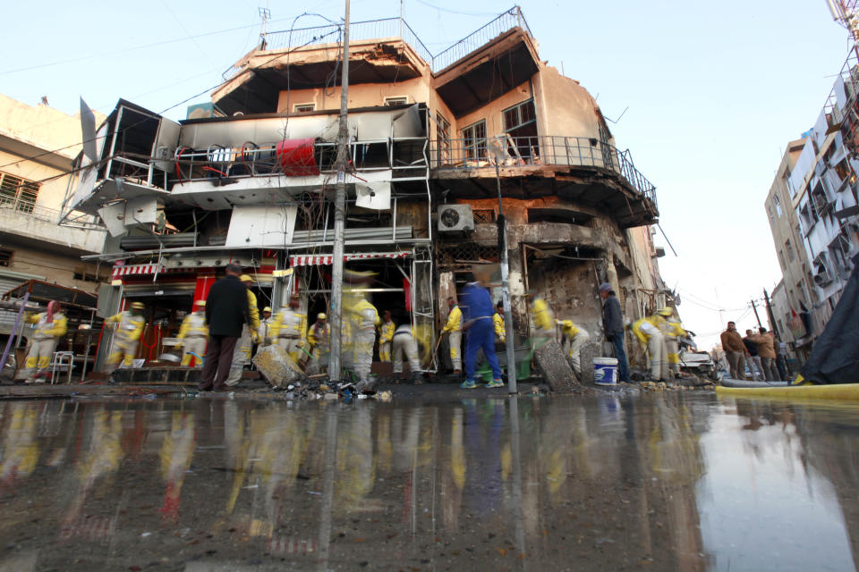 Baghdad municipality workers clean the site of a car bomb attack in Baghdad, Iraq, Tuesday, Feb. 18, 2014. A wave of explosions rocked mainly Shiite neighborhoods in Baghdad shortly after sunset on Monday, killing and wounding scores of people, said Iraqi officials. (AP Photo/Hadi Mizban)