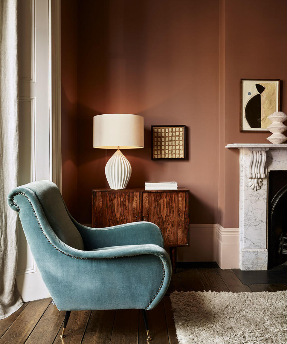 Blue armchair by sideboard with table lamp on top